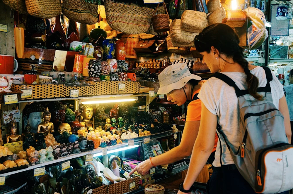 Les touristes achètent des souvenirs au marché Ben Thanh